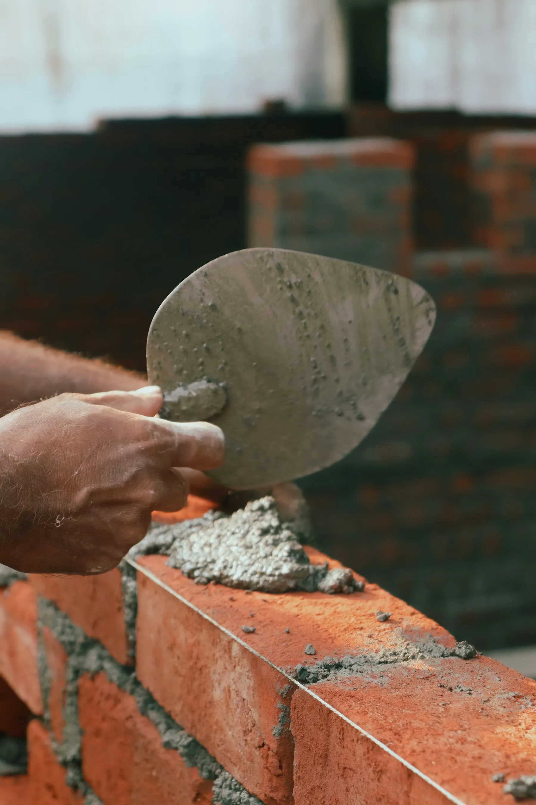 Bricklayer's trowel resting on a course of freshly laid bricks