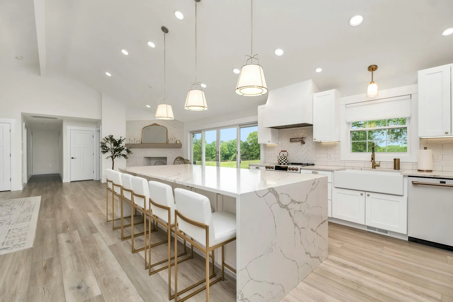 Open-plan kitchen extension with a marble-topped island and full-height glazing