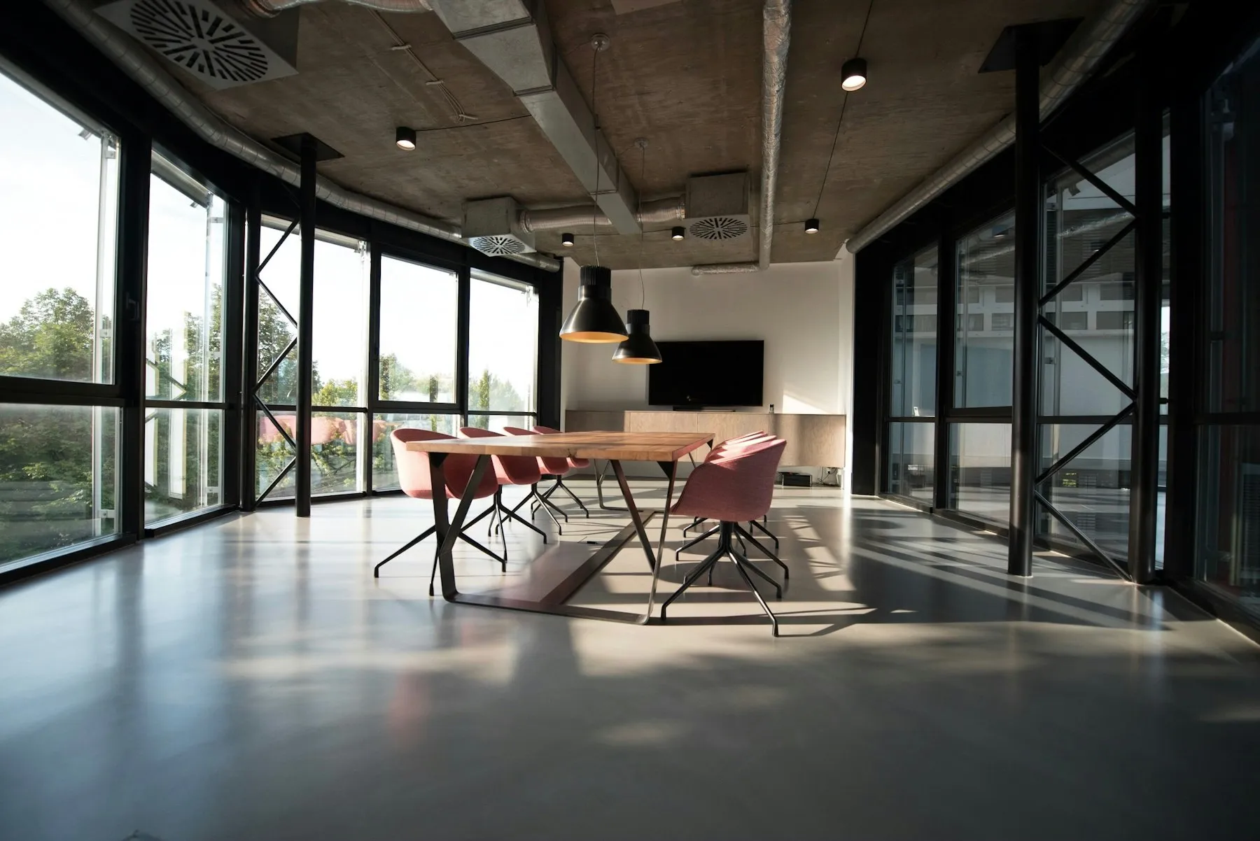Fitted-out studio office with long timber tables and pendant lighting