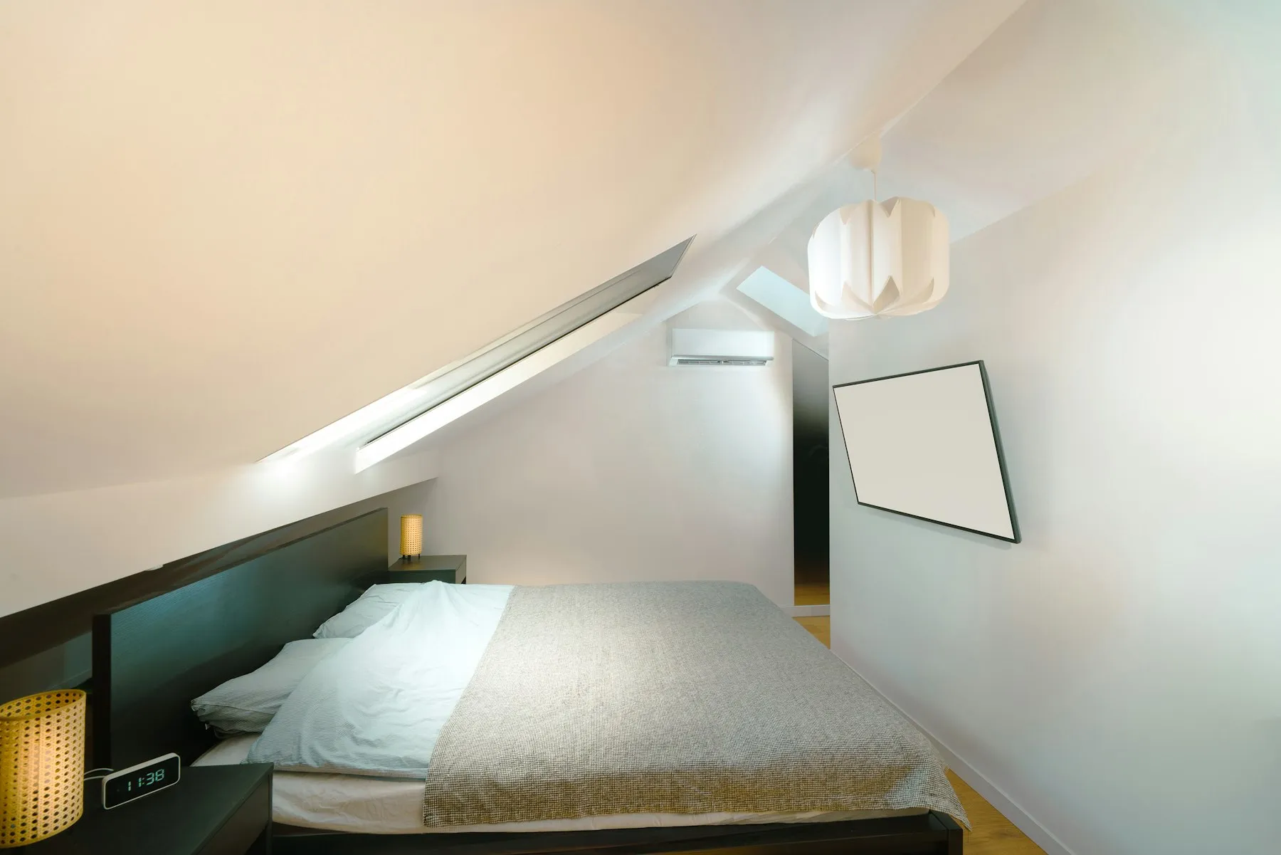 Loft bedroom beneath a sloped ceiling with natural light from a new dormer